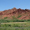 Rote Sandstein-Felsen hinter dem Dorf Chong Kyzyl Suu. Der Anfang der Wanderung verläuft durch ausgedehnte, offene Weidegebiete.