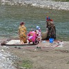 Women from the village Mogien washing carpets in the river.