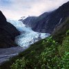 Eine Kombination von der grünen Vegetation und dem blauen Eis ist immer eine Augenweide, wie hier bei dem 11 km langen Franz-Josef-Gletscher im Westland Nationalpark. Gemeinsam mit dem weiter südlich gelegenen Fox-Gletscher ist er einer der am tiefsten (bis auf ca. 400 m über die Meereshöhe) reichenden Gletscher mittlerer Breite.
Die Nährzone des Franz-Josef-Gletschers befindet sich auf 3.300 m Höhe. Durch die hohen Niederschlagsmengen in den Neuseeländischen Alpen wird oben so viel Eis gebildet, dass die Gletscher so weit in die unteren Regionen fliessen können, wo sie von den Temperaturen her eigentlich nichts zu suchen hätten.